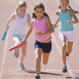 Girls running relay race